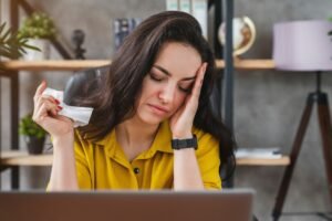 Sick business woman getting flu in office while feeling head pain